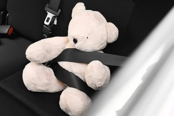 Barnets leksak Bear bucklad med säkerhetsbälte på bil baksätet. Förebyggande av fara — Stockfoto
