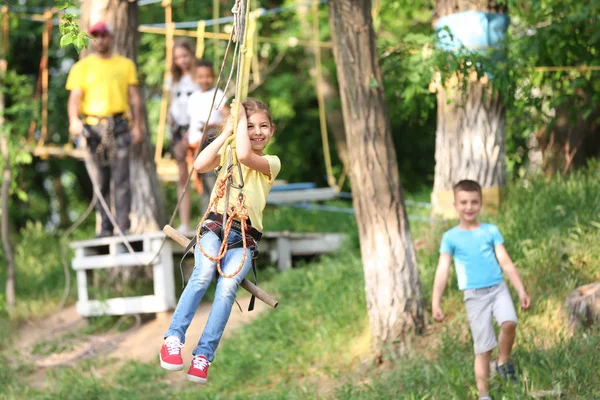 Niña en tirolina en el parque de aventuras. Campamento de verano — Foto de Stock