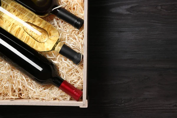 Caja de madera con botellas de vino sobre mesa gris, vista superior. Espacio para texto — Foto de Stock