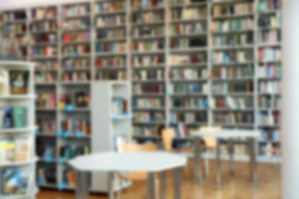 Vista borrosa de estanterías y mesas en la biblioteca —  Fotos de Stock