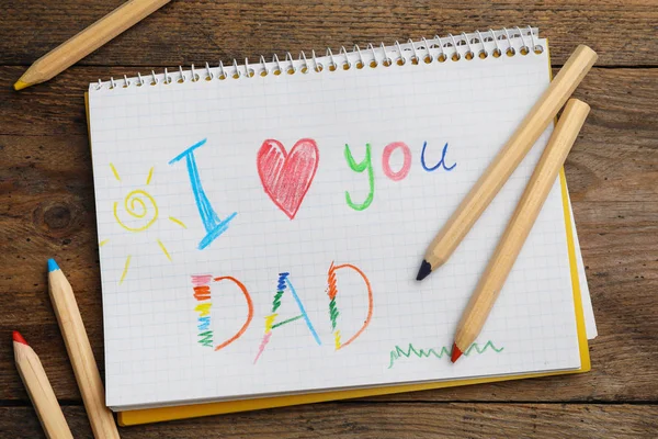 Notebook se slovy miluju tě tati a tužky na dřevěném stole, plochá — Stock fotografie