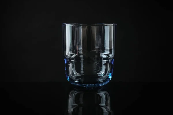 Vidro de uísque colorido vazio elegante no fundo preto — Fotografia de Stock