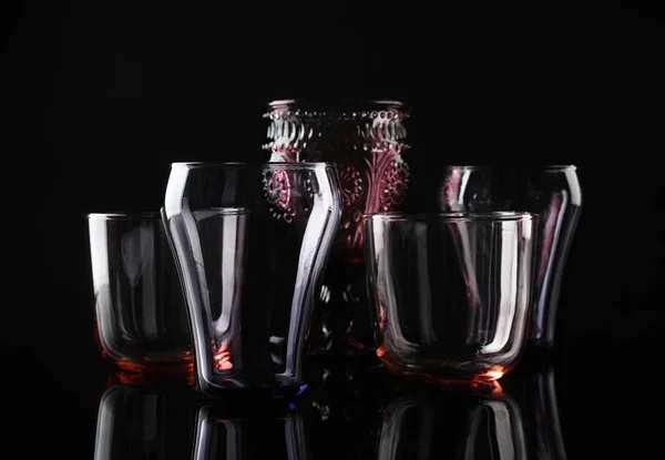 Conjunto de diferentes vasos vacíos de colores sobre fondo negro —  Fotos de Stock