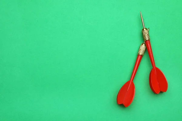 Setas de dardo vermelho no fundo verde, flat lay com espaço para texto — Fotografia de Stock