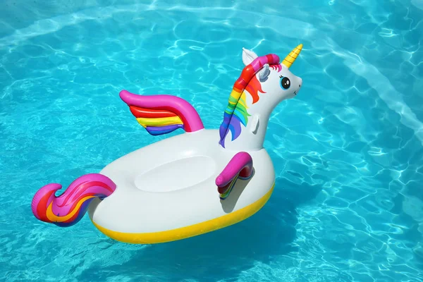 Anillo de unicornio inflable divertido flotando en la piscina en el día soleado — Foto de Stock