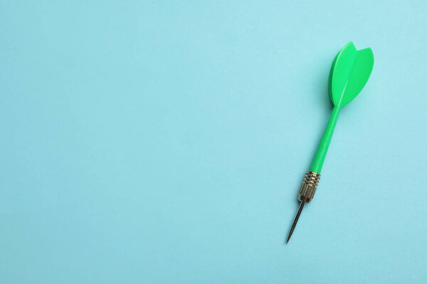 Зеленая стрелка дротик на синем фоне, вид сверху с пространством для текста
