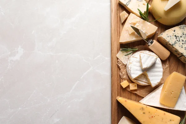 Diferentes deliciosos queijos servidos em mesa cinza, vista superior. Espaço para texto — Fotografia de Stock