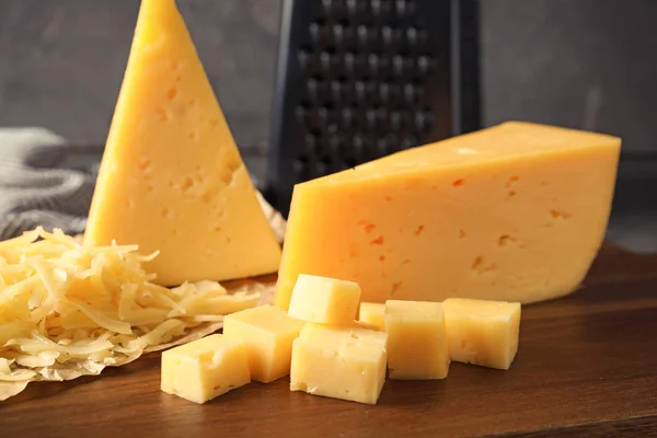 Riven och skär läcker ost ombord — Stockfoto