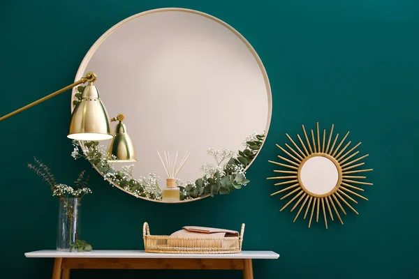 Miroir rond et table avec accessoires près du mur vert dans l'intérieur de la chambre moderne — Photo