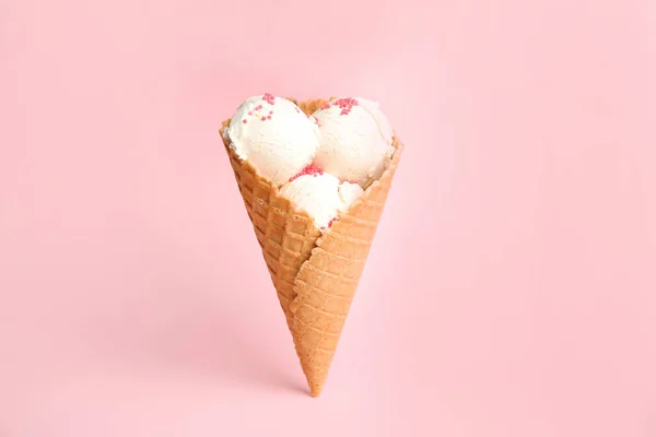 Delicioso helado de vainilla en cono de oblea sobre fondo rosa — Foto de Stock