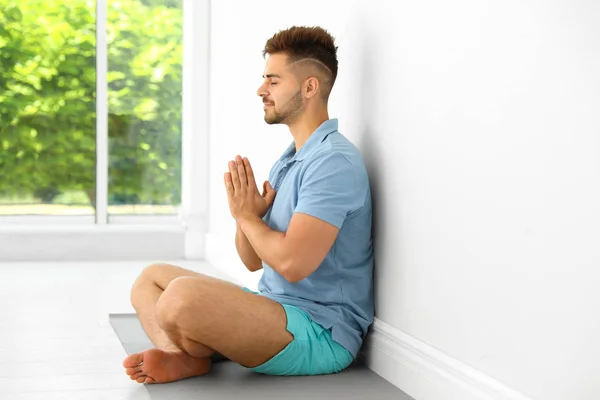 Joven practicando yoga zen cerca de la pared interior — Foto de Stock