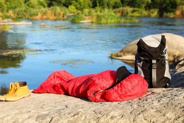 Frau ruht sich an sonnigem Tag in Schlafsack am See aus — Stockfoto