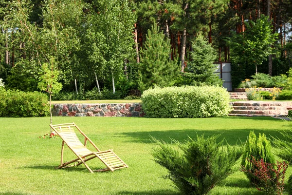 화창한 날에 아름다운 정원에서 나무 갑판 의자 — 스톡 사진