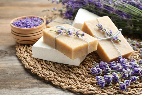 Handmade soap bars with lavender flowers on brown wooden table