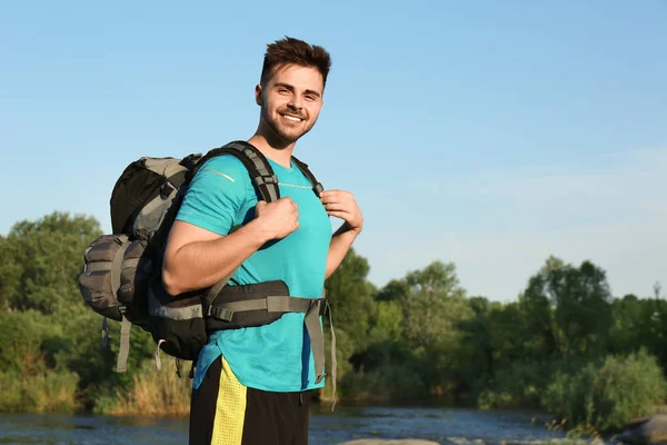 Jeune homme avec sac à dos et sac de couchage près du lac. Espace pour le texte — Photo