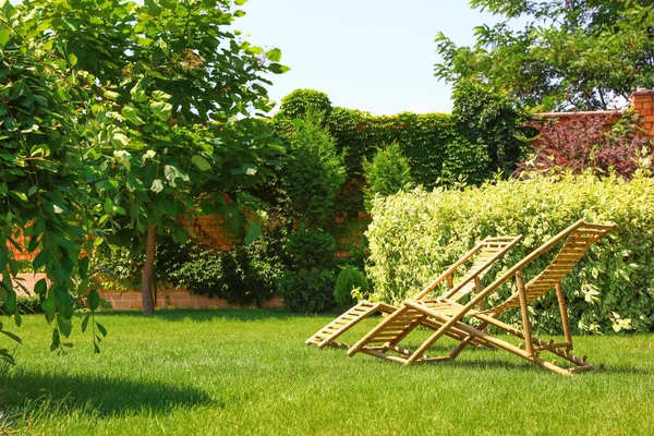 Güneşli günde bahçede ahşap şezlonglar