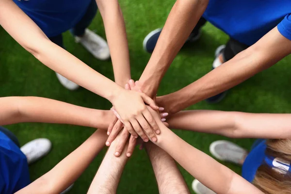 Group of volunteers joining hands together outdoors, top view — Stock Photo, Image