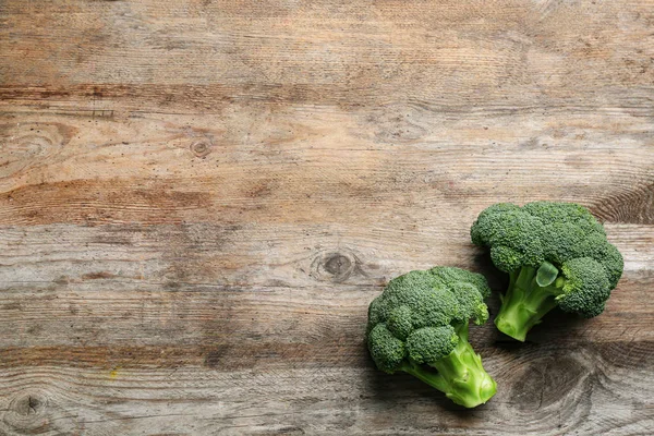 Fresh raw broccoli florets on wooden table, top view with space for text — Stock Photo, Image