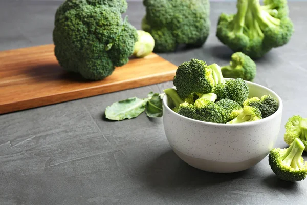 Skål med färsk broccoli på grått bord. Utrymme för text — Stockfoto