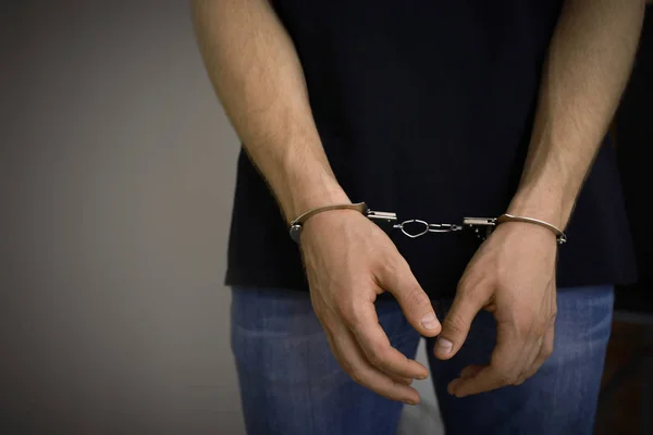 Man detained in handcuffs indoors, space for text. Criminal law — Stock Photo, Image