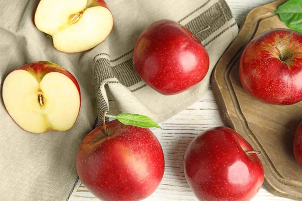 Pommes rouges juteuses mûres sur fond blanc en bois, plat — Photo