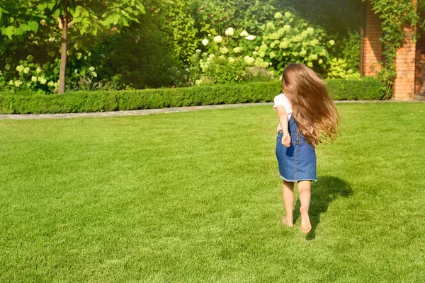 Cute dziewczynka działa w zielonym parku w letni dzień — Zdjęcie stockowe