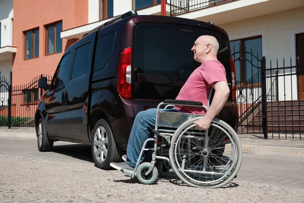Starszy mężczyzna na wózku inwalidzkim w pobliżu van na dworze — Zdjęcie stockowe