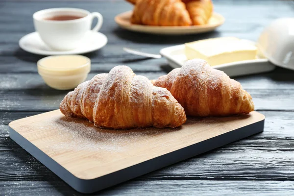 Tafel mit leckeren Croissants auf dunklem Holztisch. französisches Gebäck — Stockfoto