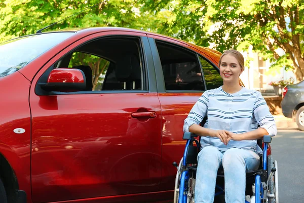 Młoda kobieta na wózku inwalidzkim w pobliżu samochodu — Zdjęcie stockowe