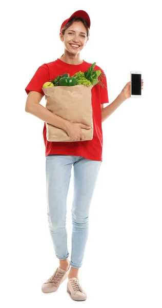 Delivery woman with bag of fresh vegetables and smartphone on white background, mockup for design — Stock Photo, Image