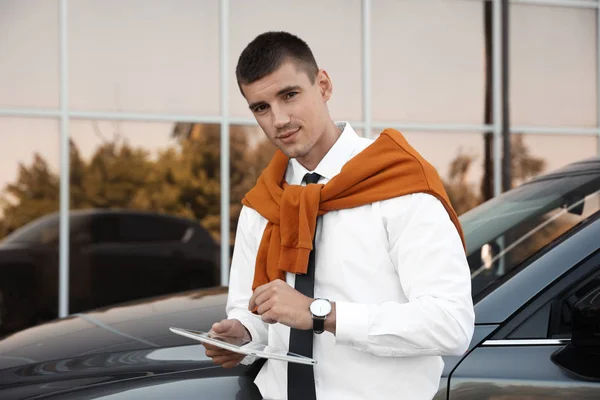 Atraktivní mladý muž s tabletem v okolí luxusního auta — Stock fotografie