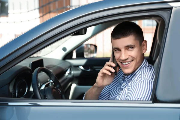 Jovem atraente falando ao telefone em carro de luxo — Fotografia de Stock