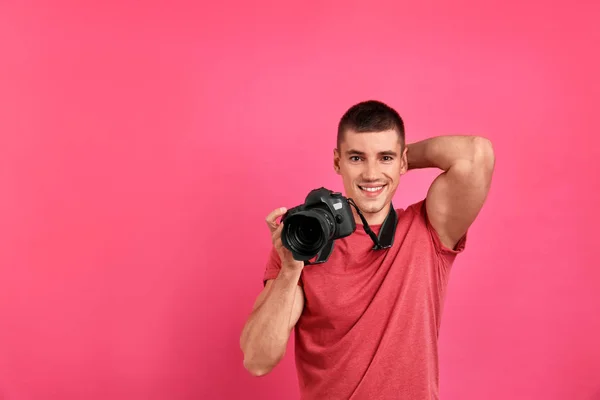 Giovane fotografo con fotocamera professionale su sfondo rosa. Spazio per testo — Foto Stock
