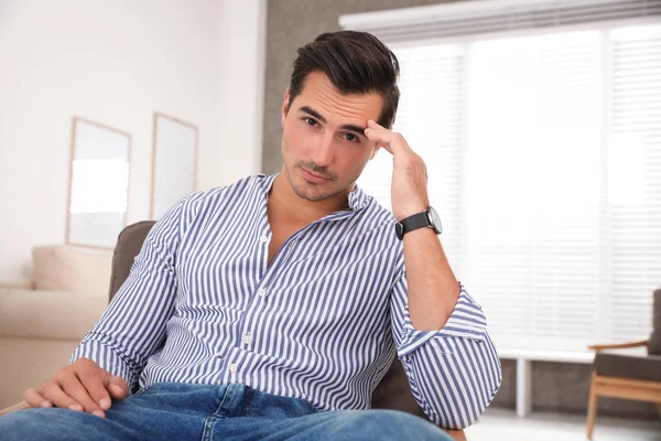 Portrait on handsome young man sitting in chair indoors — Stock Photo, Image