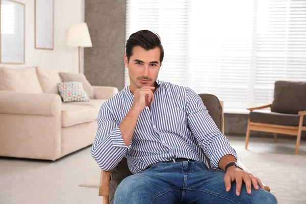 Portrait sur beau jeune homme assis dans la chaise à l'intérieur — Photo