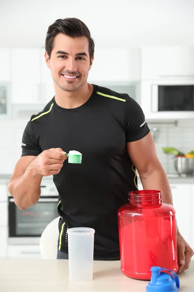 Jovem atlético homem preparando batido de proteína na cozinha — Fotografia de Stock