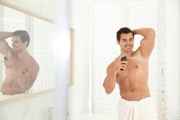 Όμορφος νεαρός άνδρας, εφαρμόζοντας αποσμητικό στο μπάνιο — Φωτογραφία Αρχείου