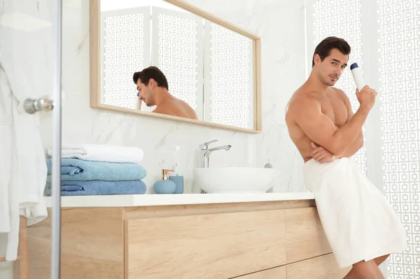 Красивий молодий чоловік з дезодорантом у ванній — стокове фото