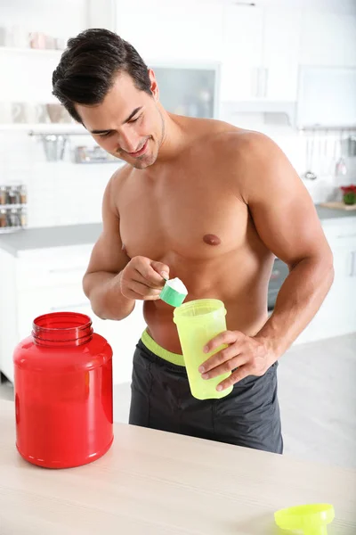 Jovem atlético sem camisa homem preparando batido de proteína na cozinha — Fotografia de Stock