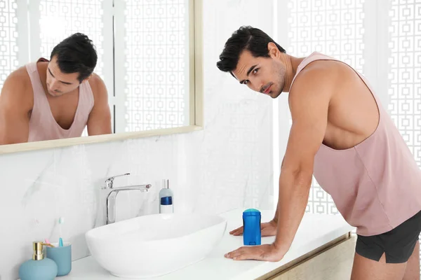 Bello giovanotto con deodorante in bagno — Foto Stock