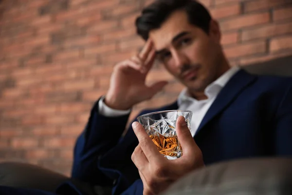 Kapalı tuğla duvar yakınında viski cam ile genç adam — Stok fotoğraf