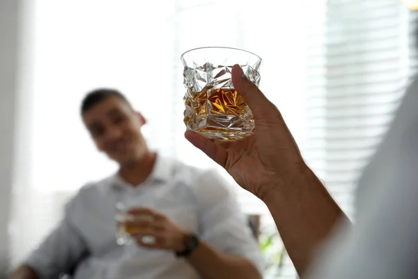 Junge Männer, die zu Hause gemeinsam Whisky trinken — Stockfoto