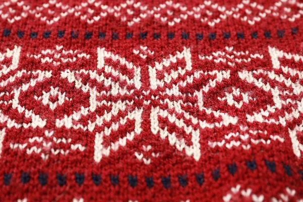 Camisola de Natal quente com flocos de neve como fundo, close-up — Fotografia de Stock