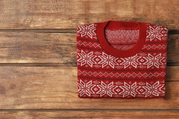 Warm folded Christmas sweater on wooden table, top view. Space for text — Stock Photo, Image