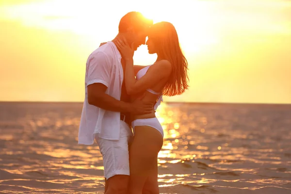 Feliz jovem casal passar tempo juntos na praia do mar ao pôr do sol — Fotografia de Stock