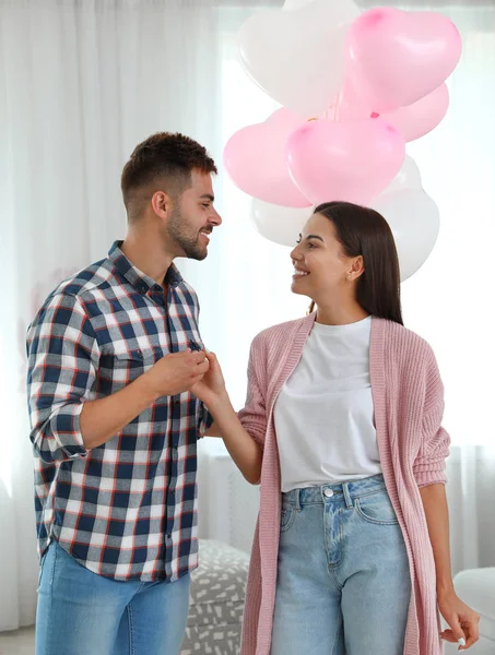 Junges Paar mit Luftballons zu Hause. Feier zum Valentinstag — Stockfoto