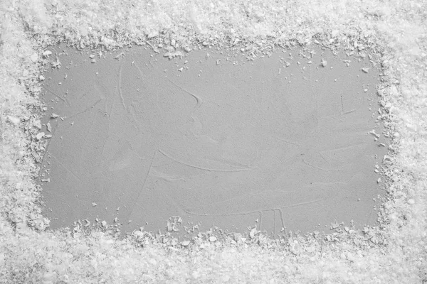 明るい灰色の石の背景に白い雪のフレーム、テキストのためのスペースを持つトップビュー。クリスマスシーズン — ストック写真