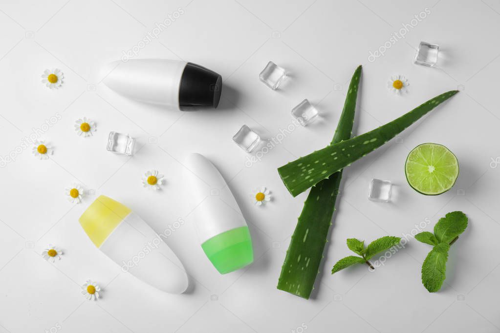 Composition with natural roll-on deodorants on white background, top view