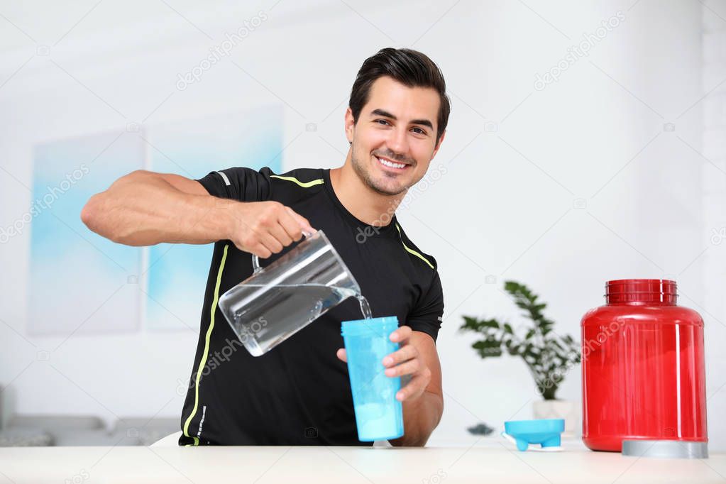 Young athletic man preparing protein shake at home
