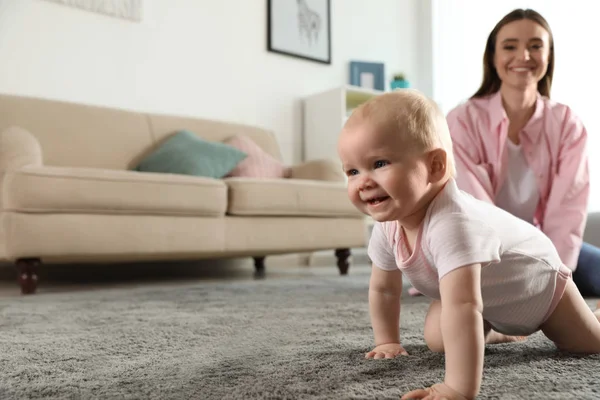 Adorable pequeño bebé arrastrándose cerca de la madre en casa —  Fotos de Stock